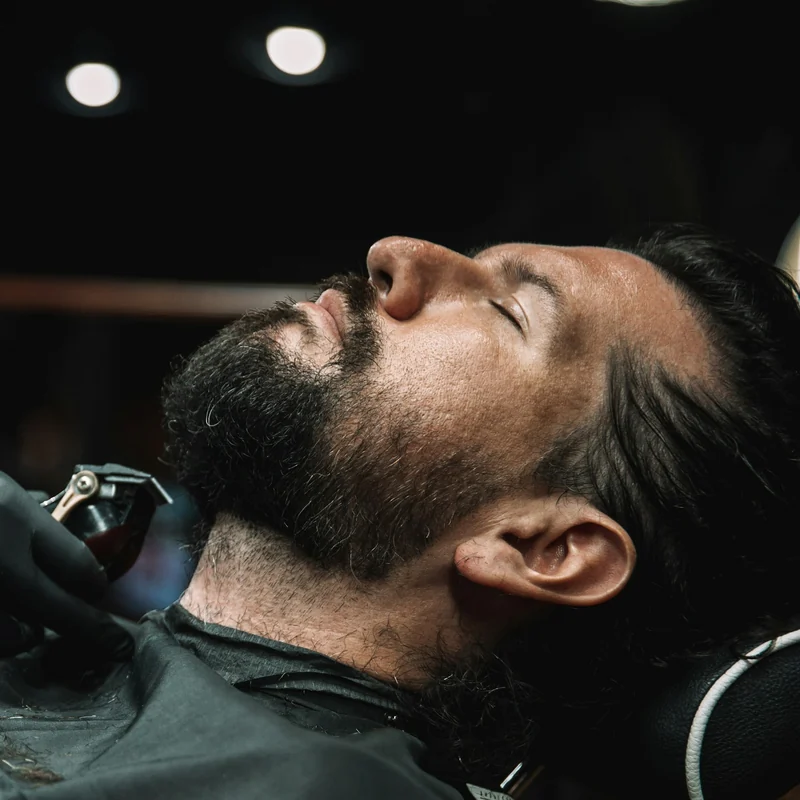 Barbeiro fazendo a barba de um cliente